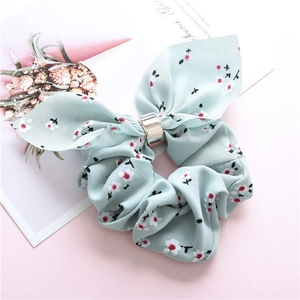 Detailed macro view of mint blue floral scrunchie with rabbit ear bow and gold metal ring