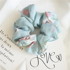 Detail of light blue floral scrunchie with pink flowers and soft cotton texture