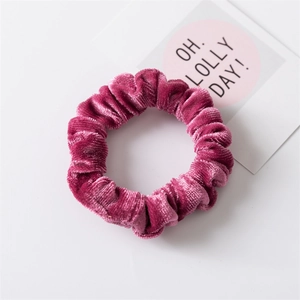 Dettaglio dell'elastico per capelli in velluto rosa con texture morbida