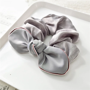 Dettaglio dell'elastico in raso grigio con fiocco e profili a righe bianche e rosse