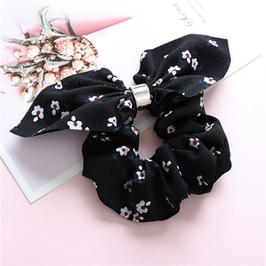 Close-up of floral scrunchie with bow knot and elegant gold metal buckle detail