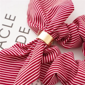 Detail of red and white striped chiffon scrunchie with a shiny gold metal buckle