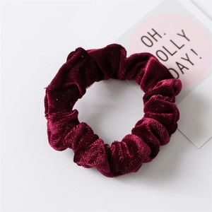 Vista dettagliata di un elastico per capelli in velluto bordeaux con texture morbida
