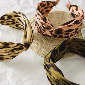 Three stylish leopard print twist knot satin headbands in beige, orange, and olive green