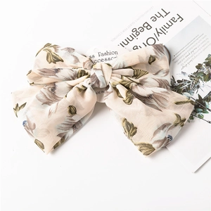 Macro detail of chiffon bow hair clip with vintage floral pattern and elegant texture