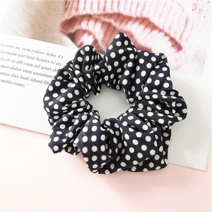 Vue détaillée du chouchou en mousseline noire avec motif à pois blancs classiques