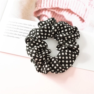 Détail du chouchou en mousseline à pois noirs et blancs avec texture plissée douce