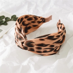 Detailed view of wide leopard print headband with satin cross-knot texture and vintage style