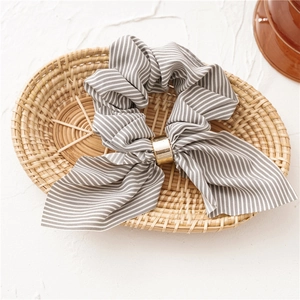 Detail of grey striped chiffon hair scrunchie with rabbit ear bow and gold metal ring