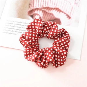 Gros plan d'un chouchou en mousseline rouge à pois blancs sur un magazine de mode