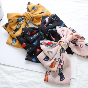 Detail of three-layer chiffon bow clips with Alice in Wonderland clock pattern
