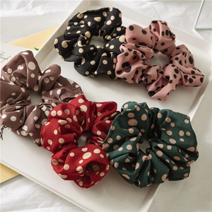 Five assorted polka dot elastic hair scrunchies in a stylish white tray display