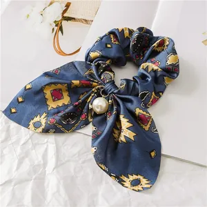 Close-up of blue geometric pattern scrunchie with large pearl pendant and long bow detail