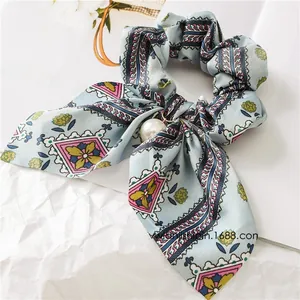 Close-up of vintage blue floral scrunchie with a large pearl pendant and long bow