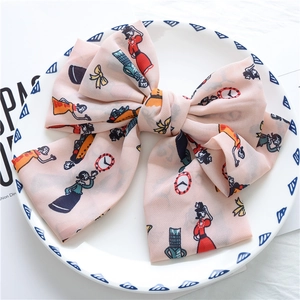 Detail of pink chiffon oversized bow hair clip with vintage cartoon and clock prints