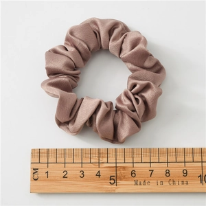 Chouchou en satin élastique mauve café, diamètre 10 cm avec règle sur fond blanc propre
