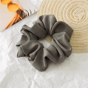 Detailed shot of dark grey oversized hair scrunchie with subtle ribbed fabric texture