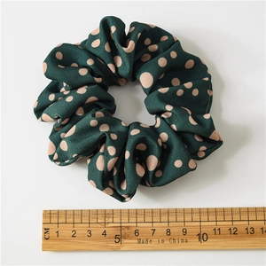 Green chiffon scrunchie with pink polka dots and 10cm diameter measurement guide