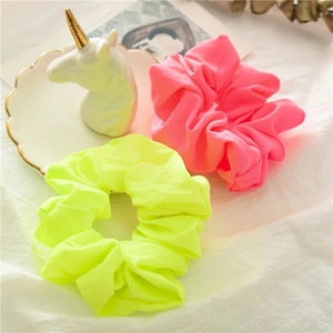 Elastici per capelli rosa e verde neon su un vassoio bianco decorativo