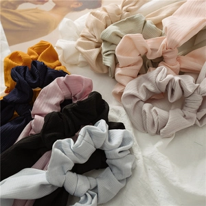 Detail shot of assorted ribbed fabric scrunchies with rabbit ear bows in various pastel colors