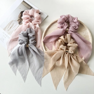 Detail of elegant chiffon hair scrunchies with long ribbons and gold metal buckles