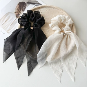 Detailed macro view of black and beige lace ribbon scrunchies with elegant rose gold metal rings