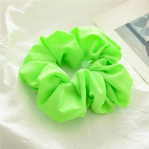 Primo piano di un elastico per capelli verde neon in tessuto opaco su sfondo bianco