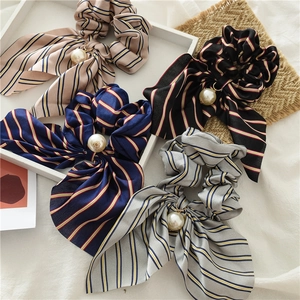 Détail de chouchous en satin avec longs rubans et pendentifs perles élégants en quatre couleurs