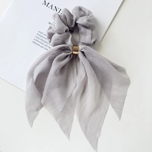 Detailed macro view of light purple bow scrunchie with silver stripes and gold metal ring
