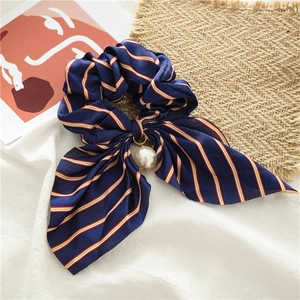 Détail du chouchou rayé bleu marine avec longs rubans et un grand pendentif perle blanche