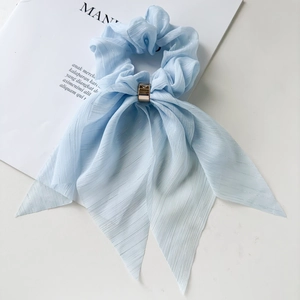 Detail of light blue chiffon scrunchie with silver silk texture and golden metal ring