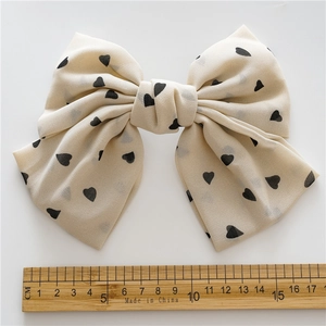 Cream chiffon double-layered bow hair clip with black heart patterns and 16cm width scale