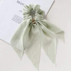 Detailed shot of mint green pleated scrunchie with lace ribbons and gold metal ring
