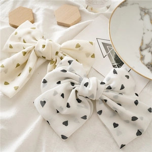Detail of chiffon heart print hair bows with 3D layered structure on marble tray