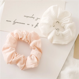 Nahaufnahme von rosa und weißen Haargummis mit feiner Strickstruktur und elastischem Design