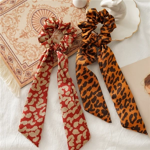 Elegant leopard print satin scrunchies with long streamers in classic orange and red tones