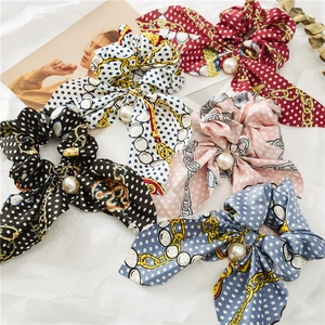 Détail de chouchous en satin multicolores avec perles élégantes et longs rubans nœuds