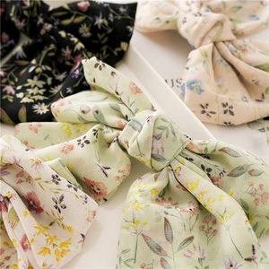 Detailed view of oversized floral chiffon bow hair clips in various pastel colors