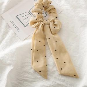 Détail d'un chouchou en mousseline fleurie à pois avec de longs rubans élégants