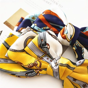 Detail of multi-layered satin bow hair clips with vintage horse harness pattern