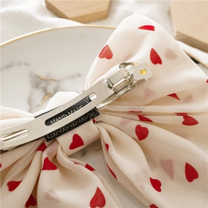 Handmade cream chiffon bow hair clip with red hearts and silver metal spring fastener