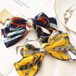 Elegant triple-layer satin bow hair clip featuring classic equestrian chain print patterns
