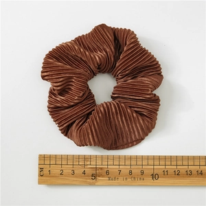 Detail of brown pleated satin scrunchie showing fabric texture and 10cm diameter scale