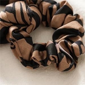 Close-up of leopard pattern scrunchie with satin texture and elegant silk sheen