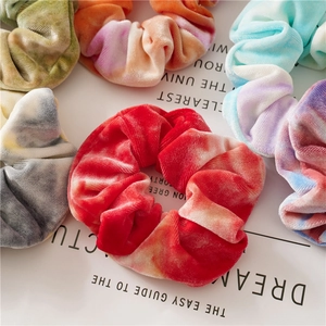 Macro shot of colorful tie-dye velvet hair scrunchies with soft texture and vibrant patterns