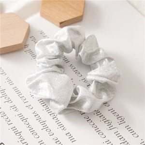 Macro-opname van zilveren glitter scrunchie met metallic glans op minimalistische achtergrond