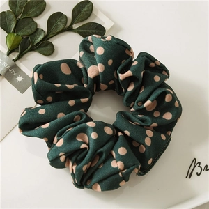 Elastic dark green hair scrunchie with pink polka dots and textured fabric finish