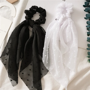 Detail of seersucker hair scrunchie with Swiss dot texture and long ribbon ties