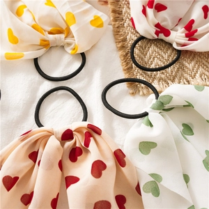 Détail de chouchous à nœuds en mousseline avec motifs de cœurs jaunes, rouges et verts