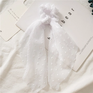 Detail of white seersucker bow scrunchie with sheer polka dot tulle and long ribbons